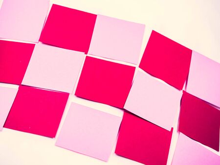 Abstract cross processed tone for vintage and retro background. Closeup of diagonal grids pattern of pink and red note paper texture.の写真素材