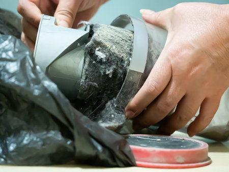 Closeup of women 's hand and vacuum cleaner plastic trash or box with dust or rubbish for cleaning conceptの写真素材