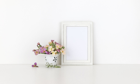 Vertical wooden frame mockup with flowers on white backgroundの写真素材