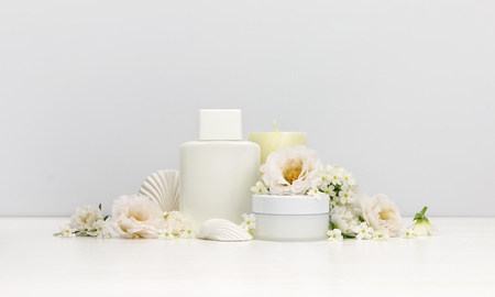 Cosmetics mockup with white flowers, bottle containの写真素材