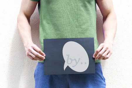 A young man holds a placard at the level of the genitalsの写真素材