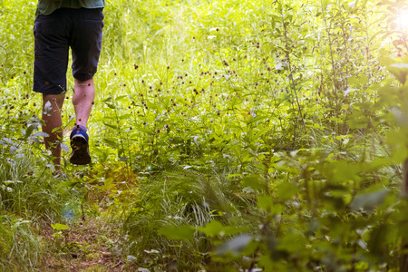 Feet of a young man walking along the path. Summer, Spring, Autumn.の写真素材