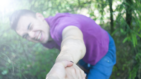 The young man pulls the girl's hand. Forest. Summer.の写真素材