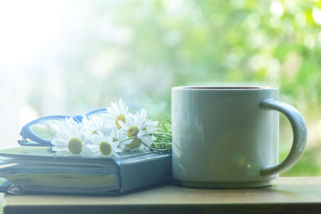 Mug, daisies, Notepad, glasses. The concept of a Sunny summer morning.の写真素材
