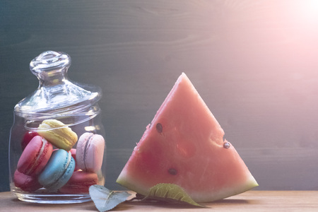 Macaroon, watermelon on a wooden table. The concept of home comfort and warmth.の写真素材