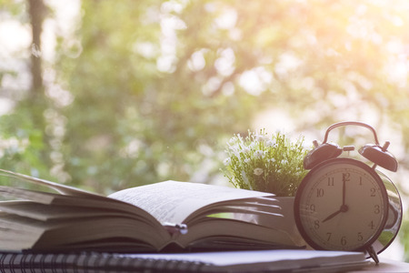 Alarm clock, notebook, vase with flowers and Apple on the desktop. The concept study.
