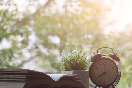 Alarm clock, notebook, vase with flowers and Apple on the desktop. The concept study.