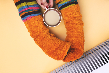Girl hot near the heater in socksの写真素材