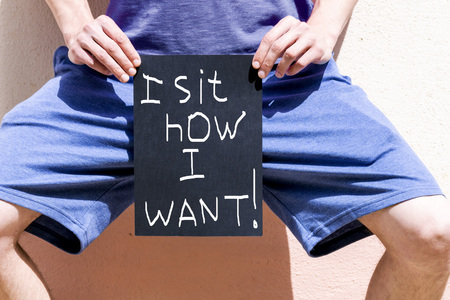 a man holds a banner reading "I sit as I want"の写真素材