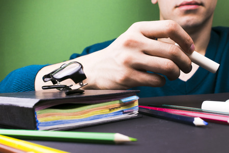 The teacher explains the topic with chalk in hand. Close-up. The concept of the study.の写真素材