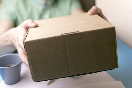 The man gives a parcel to the post office. Mail.