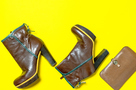 Female shoes, bag, autumn leaves on a yellow background. The concept of autumn.の写真素材