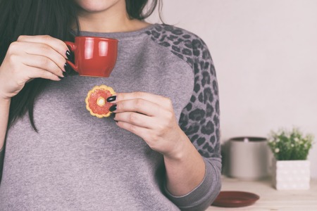 A girl drinks tea in the morning in the kitchenの写真素材