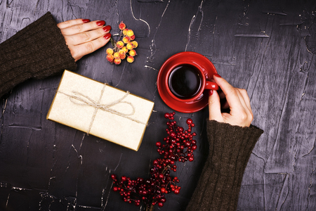 Girl holding red Cup of coffee on dark backgroundの写真素材