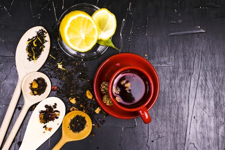 A variety of teas, spices and fruits on dark textured background.の写真素材
