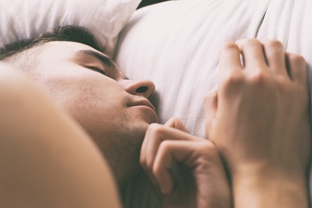Young man sleeping in bedの写真素材