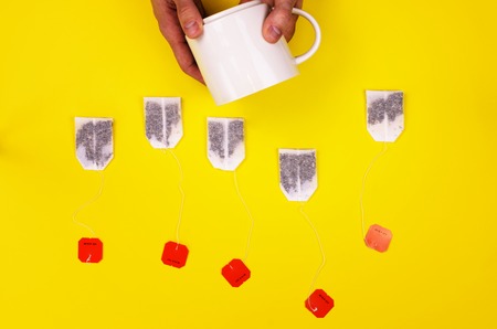 A set of teabags with black tea along the yellow background. Vivid concept of the tea partyの写真素材