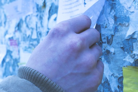 The man pulls the ad on the Board. Winter. Unemployedの写真素材