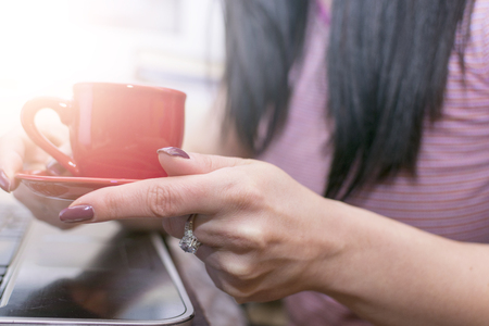 Girl drinking coffee in front of the computer. Intervalの写真素材