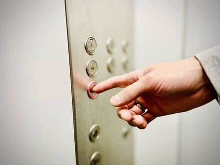 The man presses the elevator button with his hand. A close-up. Mobile photoの写真素材