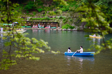Tourists rowing a boat on the river in Arashiyama, Kyoto, Japan.の写真素材