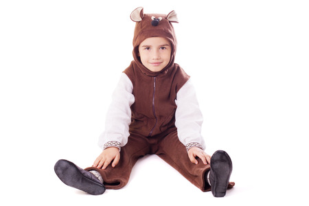 Playful boy wearing in a bear costume sits on a floorの写真素材