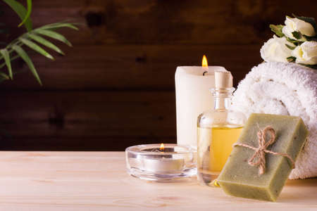 Image of spa concept with flowers, candles, sea salt, oil, towel and natural bar of soapの写真素材