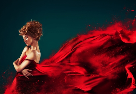 Woman in red blowing flying red dress dissolving in splashの写真素材