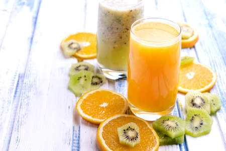 Glass of freshly pressed orange juice with sliced orange half on wooden tableの写真素材