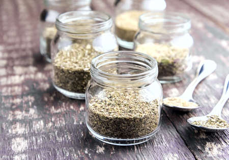 Glass jars with dry herb Chamomile Nettle Plantain on wooden backgroundの写真素材