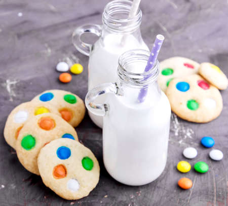 Milk and homemade cookie with colored chocolate candyの写真素材