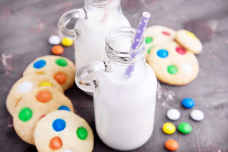 Milk and homemade cookie with colored chocolate candyの写真素材