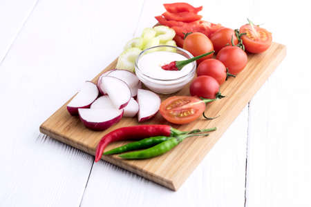 Chopped vegetables: carrots, parsley and onion on cutting boardの写真素材