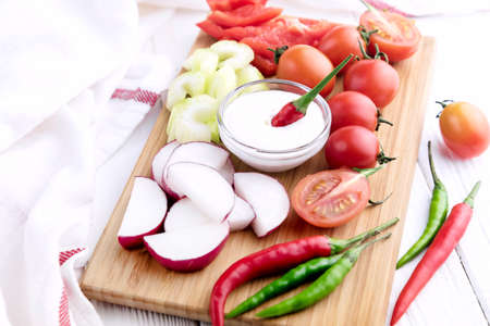 Chopped vegetables: carrots, parsley and onion on cutting boardの写真素材