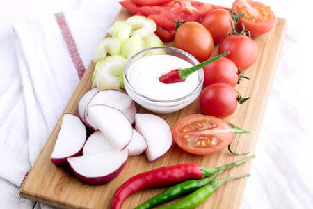Chopped vegetables: carrots, parsley and onion on cutting boardの写真素材