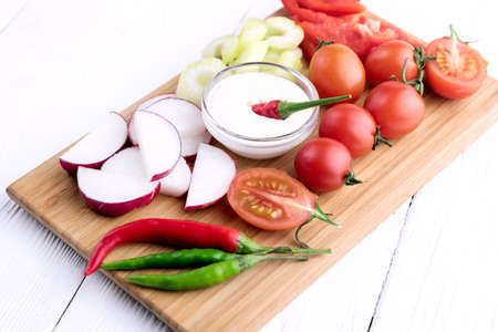 Chopped vegetables: carrots, parsley and onion on cutting boardの写真素材