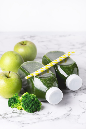 Healthy Detox Green Smoothie with Green Apples and Ripe Broccoli in Bottles Healthy Diet Food Drink Vertical Copy Space White Backgroundの写真素材
