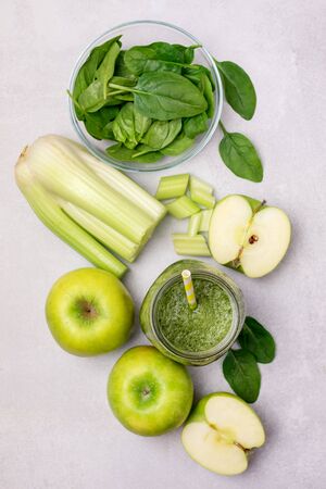 Glass Jar of Healthy Green Smoothie Detox Drink with Green Apple Celery and Raw Spinach Diet Beverage Vertical Top Viewの写真素材