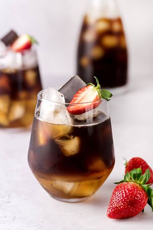 Glasses of Homemade Cold Brew Coffee to Drink for Breakfast Summer Beverage with Ice Cubes Decorated with Strawberry and Chocolate Vertical Close Upの写真素材