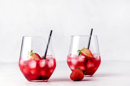 Glasses of Tasty Cranberry Cocktail with Ice Cubes on light Gray Background Alcoholic Drink Straws Horizontalの写真素材