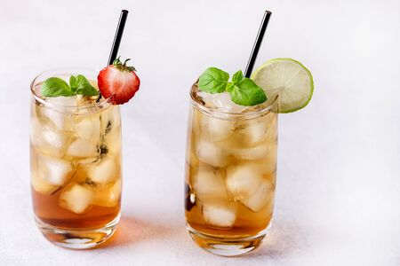 Glasses of Cold Citrus and Strawberry Ice Tea Decorated with Slice of Lemon and Strawberry Healthy Summer Drink Horizontalの写真素材
