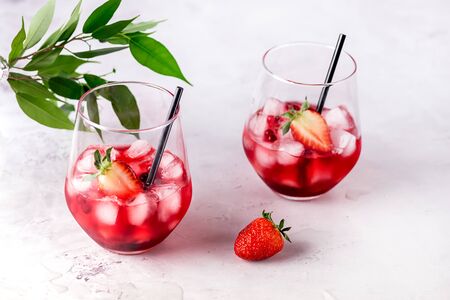 Glasses of Tasty Cranberry Cocktail with Ice Cubes on light Gray Background Alcoholic Drink Straws Horizontalの写真素材