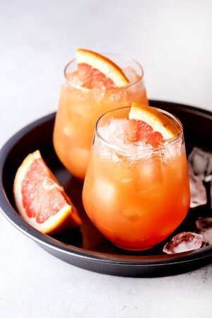 Glasses of Cold and Tasty Pink Grapefruit Juice Decorated with Slice of Ripe Grapefruit Cold Juice or Beverage Verticalの写真素材