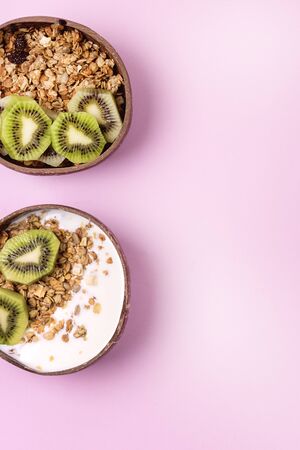 Coconut Bowl With Fresh Kiwi and Granola or Muesli Bowl of Homemade Granola for Healthy Breakfast Diet Food Vertical Copy Spaceの写真素材