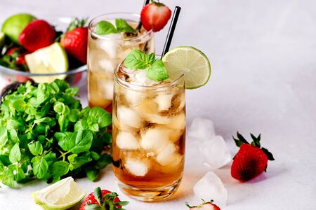 Glasses of Cold Citrus and Strawberry Ice Tea Decorated with Slice of Lemon and Strawberry Healthy Summer Drink Horizontalの写真素材