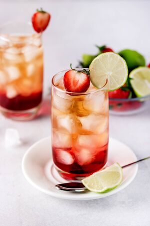 Glasses of Strawberries and Lime Ice Tea Refreshing Healthy Summer Drink Light Gray Background Verticalの写真素材