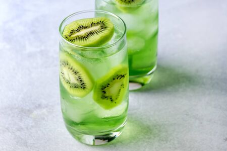 Glass of Refreshing Tropical Kiwi Lemonade With Ice on Light Gray Background Tasty Summer Beverage Healthy Detox Diet Drinkの写真素材