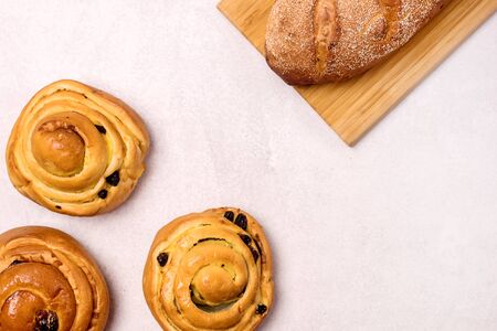 Freshly Baked Buns with Raisins and Cinnamon on Light Gray Background Top view Sweet Homemade Pastry Swedish Dessert Copy Spaaceの写真素材