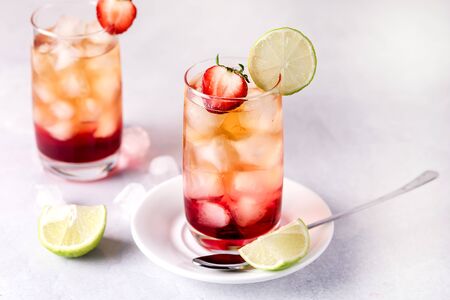 Glasses of Cold Citrus and Strawberry Ice Tea Decorated with Slice of Lemon and Strawberry Healthy Summer Drink Horizontalの写真素材