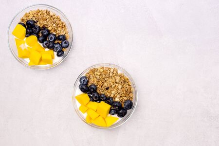 Bowls of Muesl and Yogurt with Berry and Mango Healthy Breakfast Diet Food Copy Spaceの写真素材